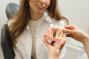 Dental Patient Getting Shown A Dental Implant Model During Her Consultation in San Antonio, TX
